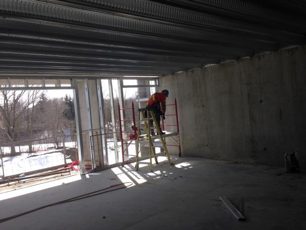 worker on a ladder near a balcony opening